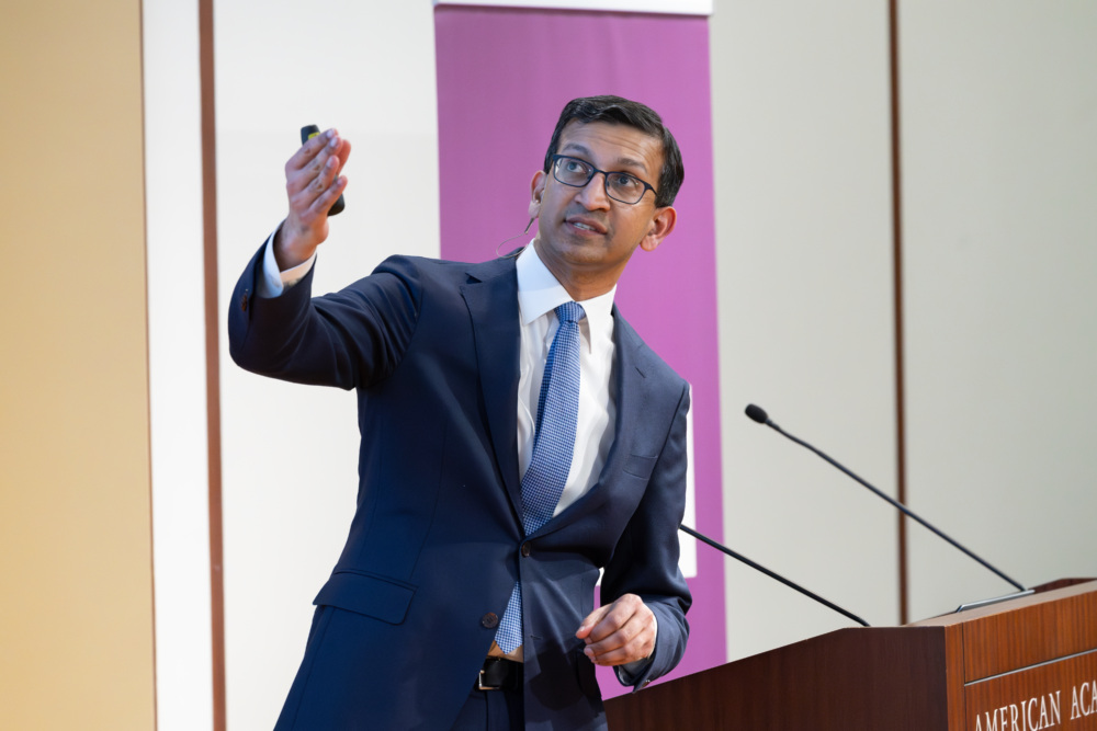Raj Chetty gestures while speaking at the Social Finance Institute Launch event